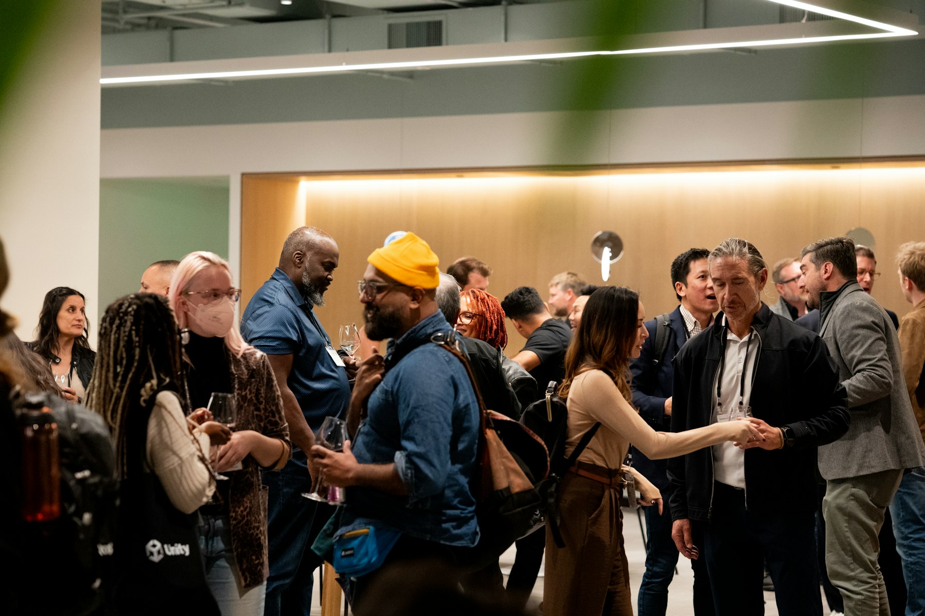 An indoor gathering with warm lighting and people in conversation.