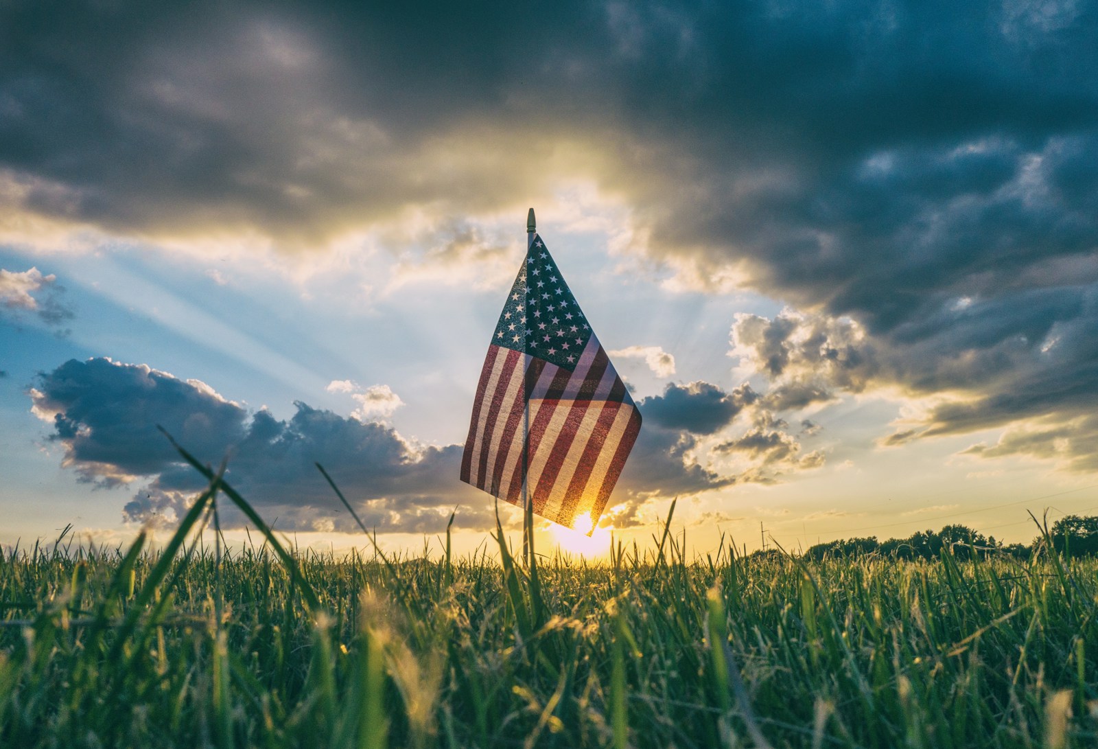 An American flag standing in a grass field.